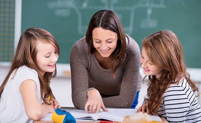 Schülerinnen lernen gemeinsam mit einer Lehrerin